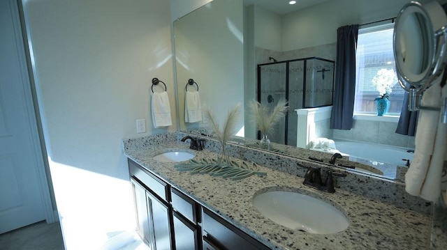 bathroom featuring vanity and independent shower and bath