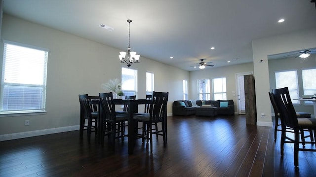 dining area featuring dark wood-type flooring and ceiling fan with notable chandelier