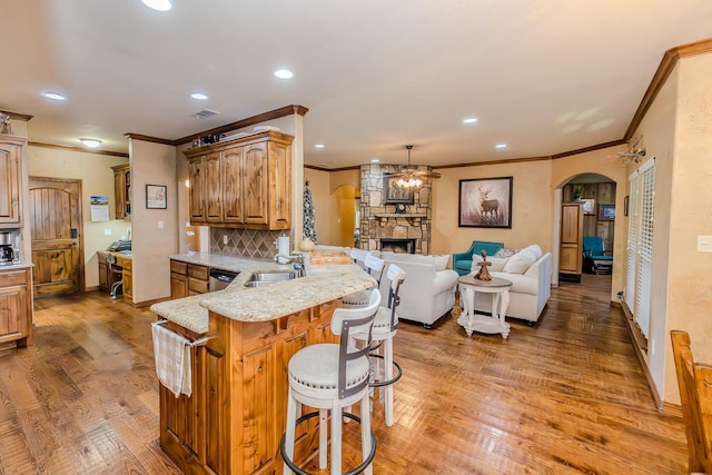 kitchen featuring pendant lighting, wood-type flooring, sink, a breakfast bar area, and kitchen peninsula