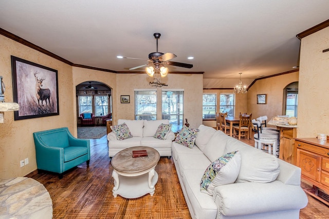 living room with crown molding, dark hardwood / wood-style floors, and ceiling fan with notable chandelier