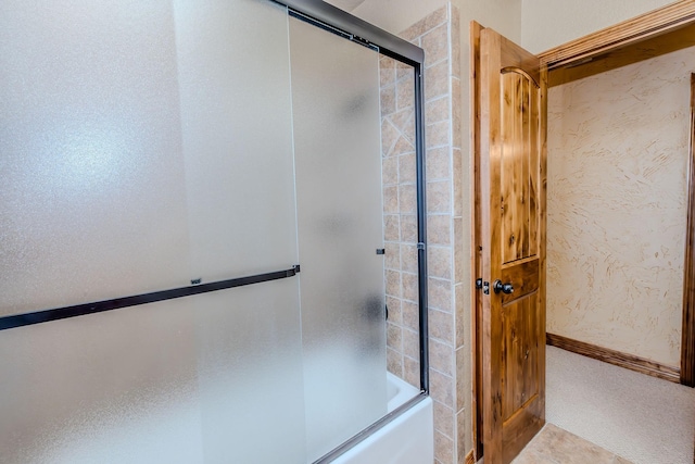 bathroom with bath / shower combo with glass door