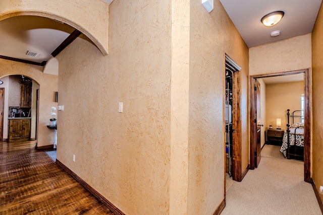 corridor with hardwood / wood-style flooring