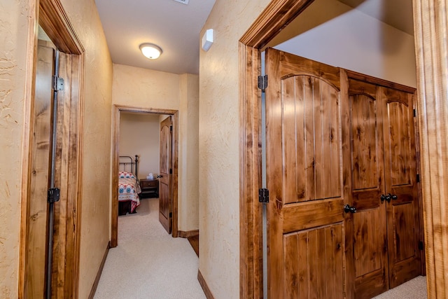 hall with light colored carpet