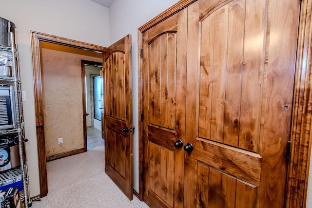 hallway featuring light colored carpet