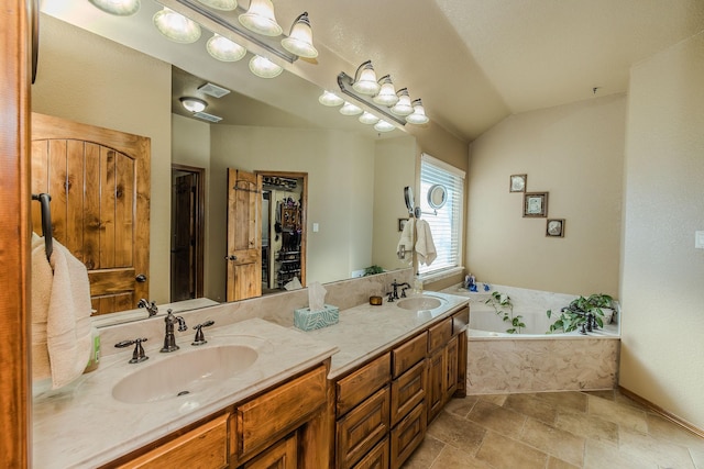 bathroom with vanity, lofted ceiling, and a washtub