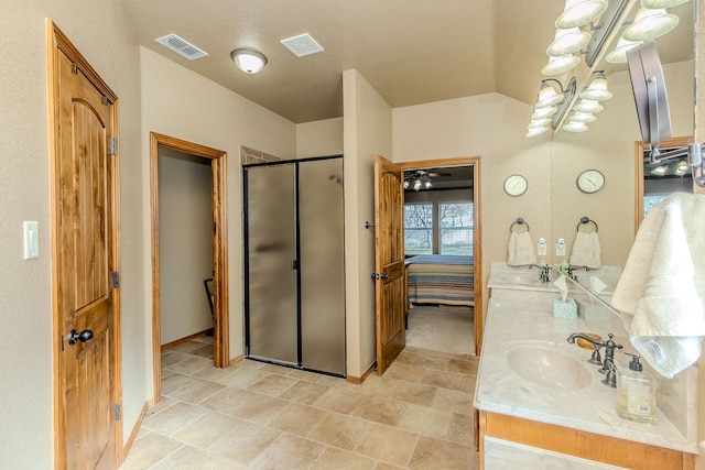 bathroom featuring vanity, a shower with shower door, and vaulted ceiling