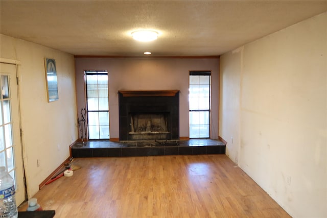 unfurnished living room with a textured ceiling, light hardwood / wood-style floors, and a fireplace