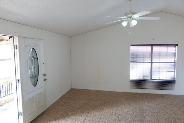 foyer entrance with carpet flooring, ceiling fan, and vaulted ceiling