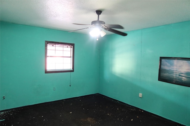 empty room with a textured ceiling and ceiling fan