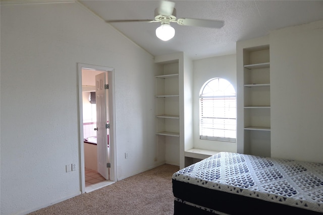 bedroom with vaulted ceiling, ceiling fan, light colored carpet, and a textured ceiling