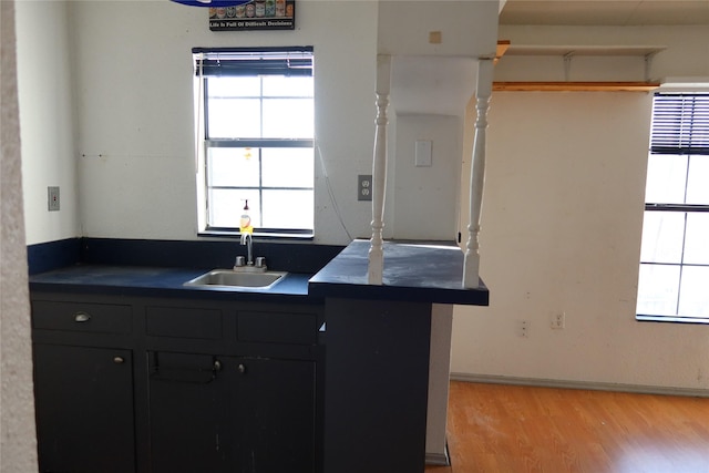 kitchen featuring kitchen peninsula, sink, and light hardwood / wood-style flooring