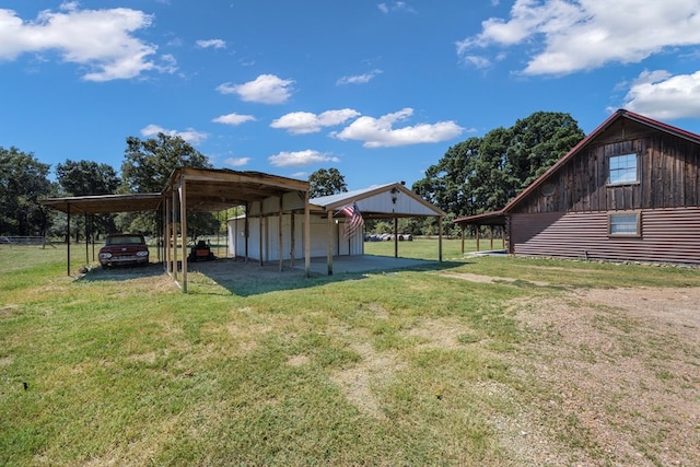 view of yard featuring a carport and an outbuilding