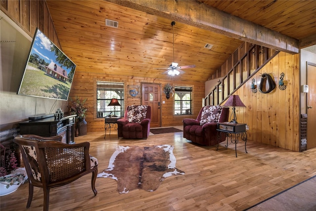 living room with hardwood / wood-style flooring, plenty of natural light, wood walls, and wood ceiling