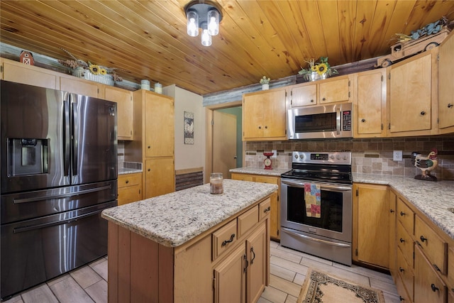 kitchen with tasteful backsplash, light stone counters, a kitchen island, and stainless steel appliances