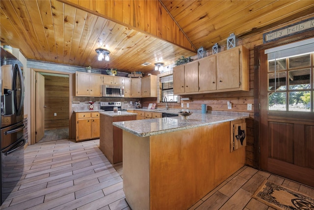 kitchen featuring kitchen peninsula, a wealth of natural light, a kitchen island, and stainless steel appliances