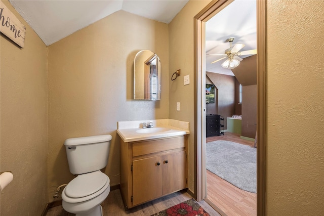 bathroom featuring hardwood / wood-style floors, vanity, vaulted ceiling, ceiling fan, and toilet