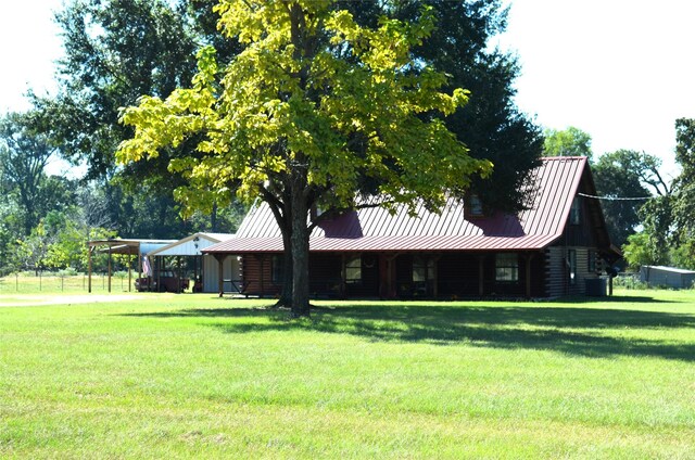 log-style house with a carport, central air condition unit, and a front yard