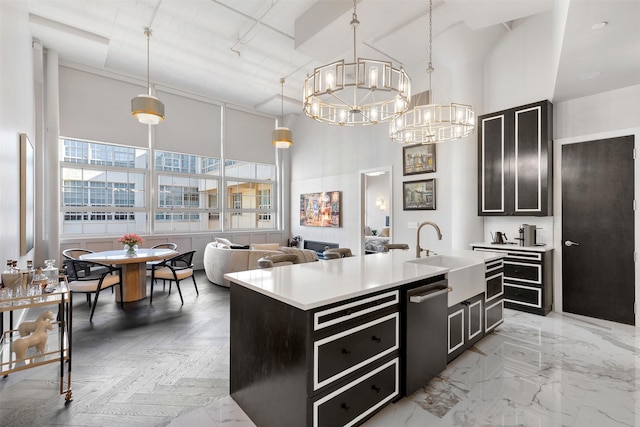 kitchen featuring pendant lighting, sink, a chandelier, stainless steel dishwasher, and a center island with sink