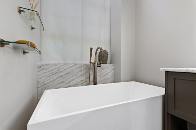 bathroom with vanity and a bath