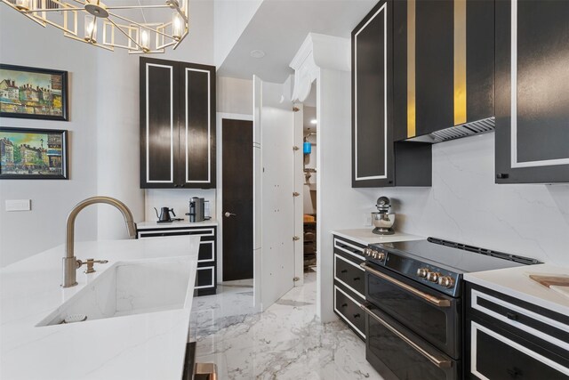 kitchen with a towering ceiling, hanging light fixtures, a center island with sink, and a breakfast bar area