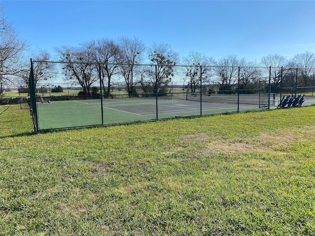 view of tennis court with a yard