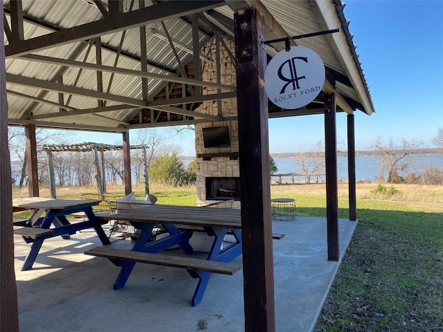 view of patio with a gazebo and an outdoor stone fireplace