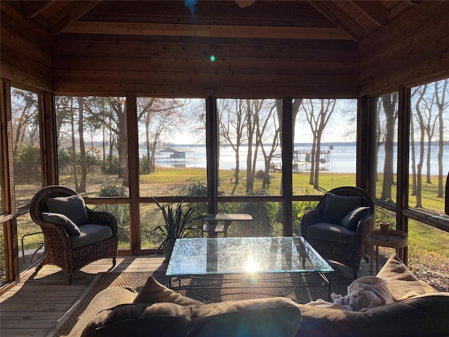 sunroom featuring a water view and vaulted ceiling