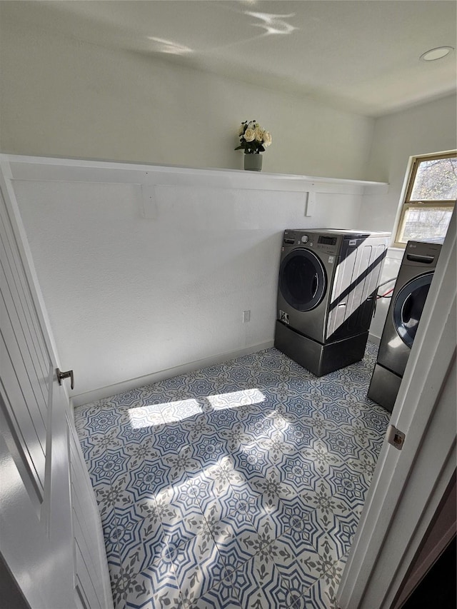 laundry area featuring light tile patterned floors and washer / dryer