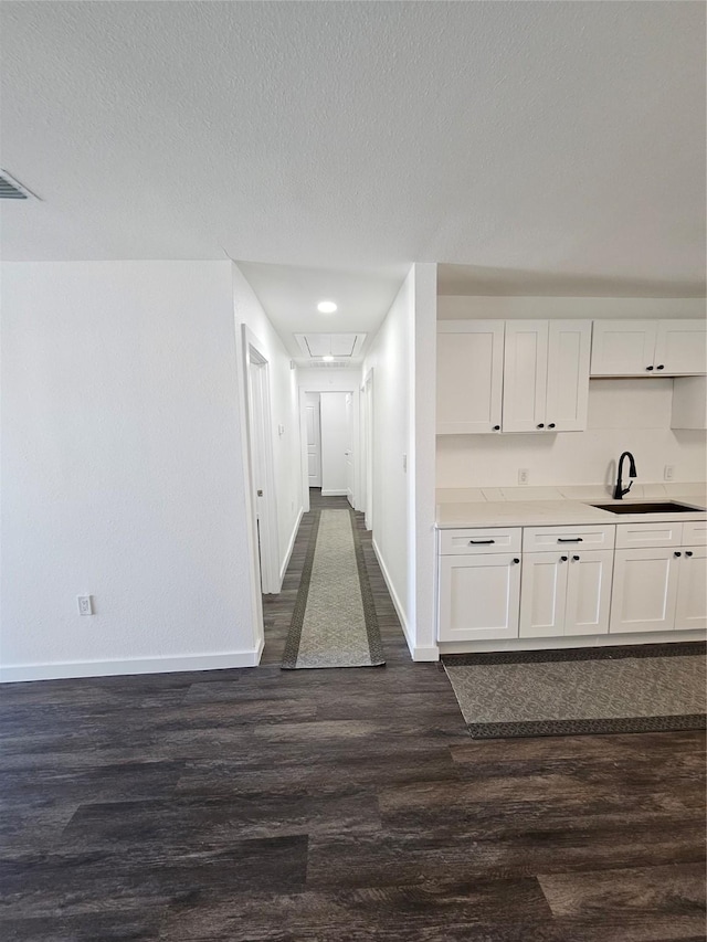 hall featuring sink, a textured ceiling, and dark hardwood / wood-style floors