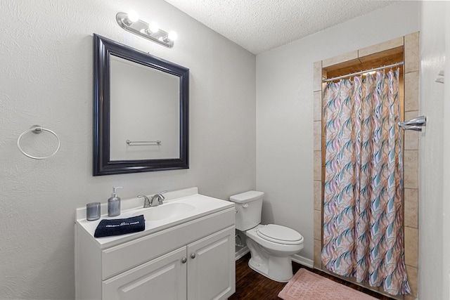 bathroom with hardwood / wood-style floors, a textured ceiling, toilet, vanity, and a shower with shower curtain