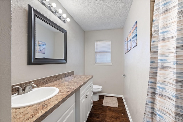 bathroom with vanity, hardwood / wood-style floors, a textured ceiling, and toilet