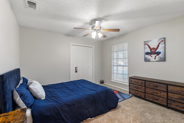 carpeted bedroom featuring a textured ceiling, a closet, and ceiling fan