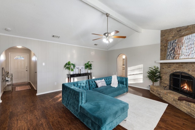 living room with a fireplace, lofted ceiling with beams, ceiling fan, and dark wood-type flooring