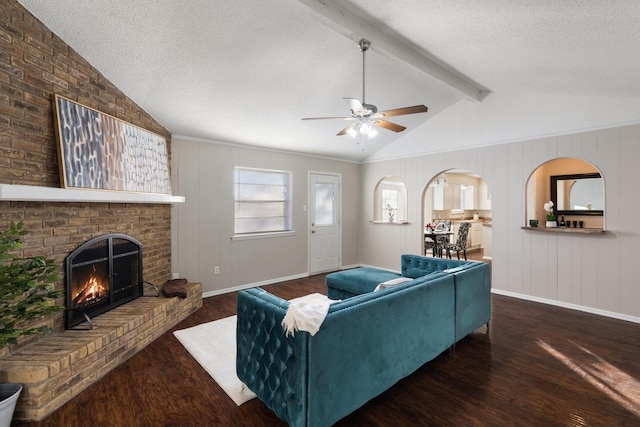 living room featuring dark hardwood / wood-style flooring, a textured ceiling, lofted ceiling with beams, and ceiling fan