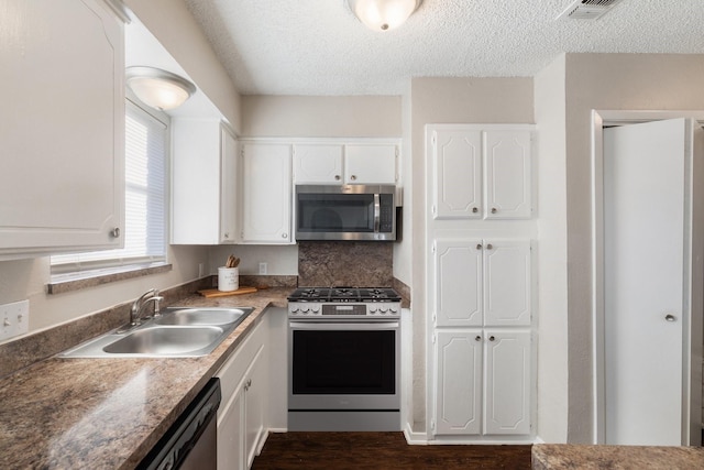 kitchen featuring white cabinets, sink, appliances with stainless steel finishes, and a textured ceiling