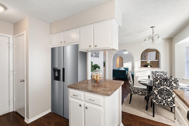 kitchen with white cabinets, stainless steel refrigerator with ice dispenser, dark hardwood / wood-style floors, a textured ceiling, and decorative light fixtures