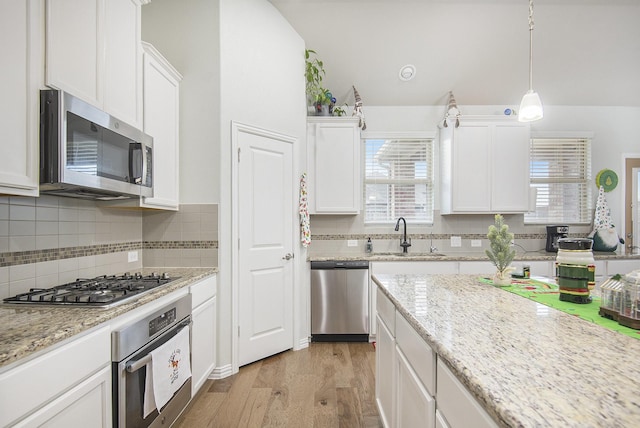 kitchen with stainless steel appliances, white cabinetry, and sink