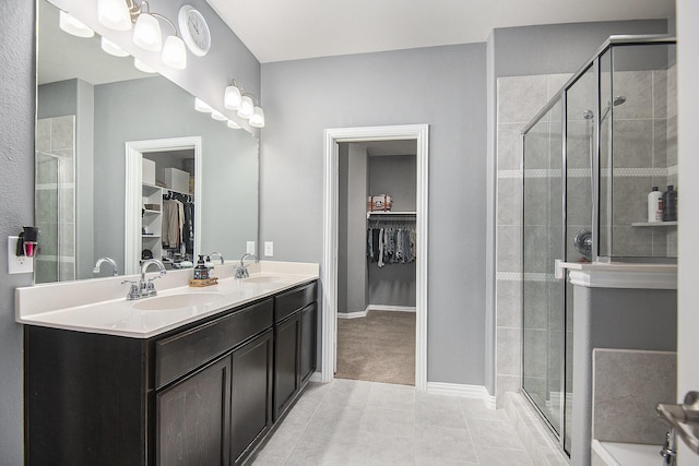 bathroom featuring tile patterned flooring, vanity, and a shower with door