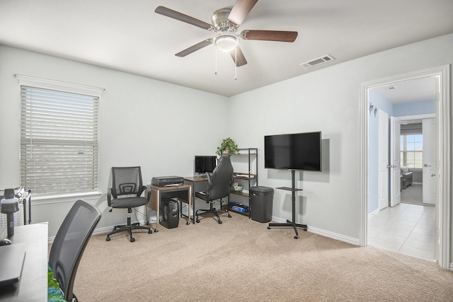 carpeted home office featuring ceiling fan