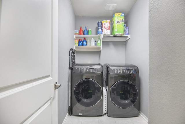 laundry room featuring washer and dryer and light tile patterned flooring