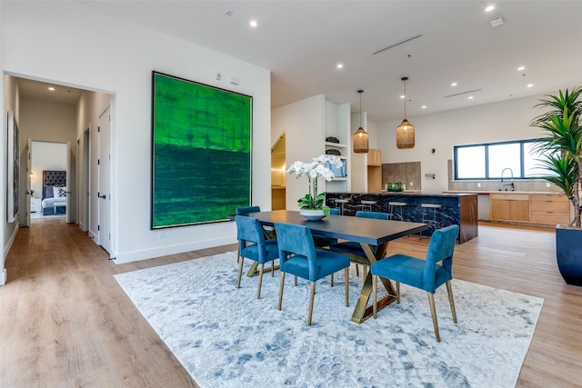 dining area with sink and light wood-type flooring