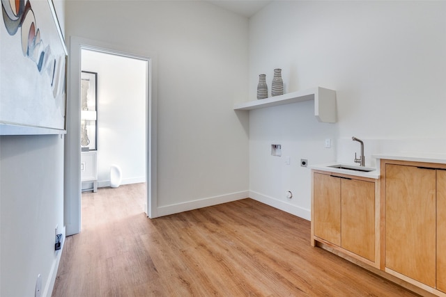 laundry room with sink, cabinets, hookup for a washing machine, electric dryer hookup, and light wood-type flooring