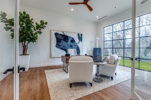 living area featuring french doors, ceiling fan, a healthy amount of sunlight, and hardwood / wood-style floors