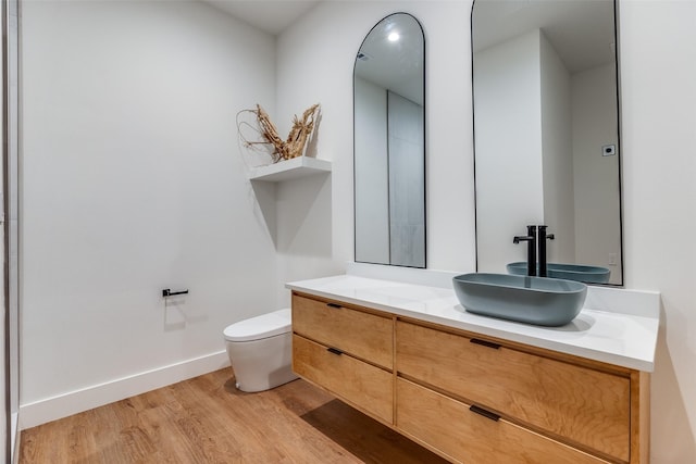 bathroom featuring vanity, hardwood / wood-style flooring, and toilet