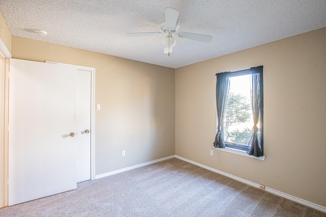 carpeted empty room featuring a textured ceiling and ceiling fan