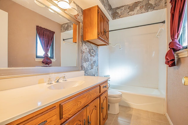 full bathroom featuring tile patterned flooring, vanity, tiled shower / bath combo, and toilet