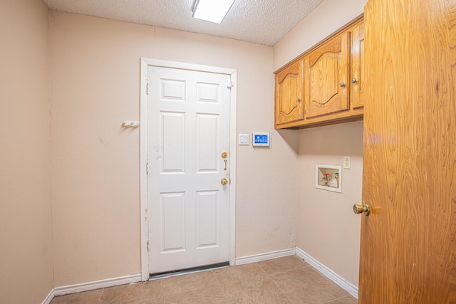 laundry area featuring cabinets, hookup for a washing machine, and a textured ceiling