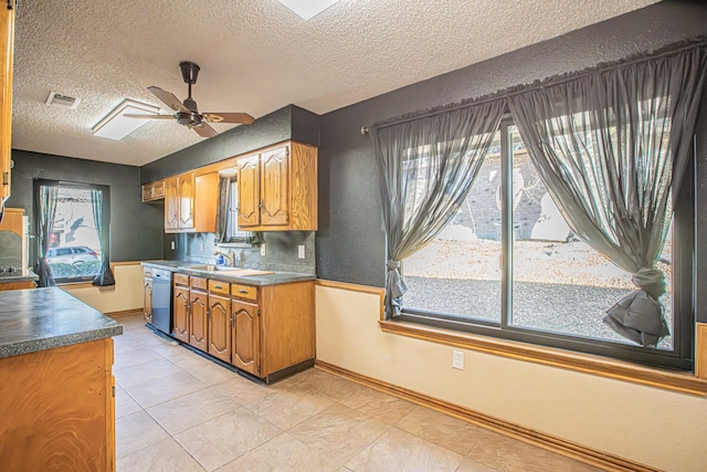 kitchen featuring dishwasher, ceiling fan, sink, and a textured ceiling