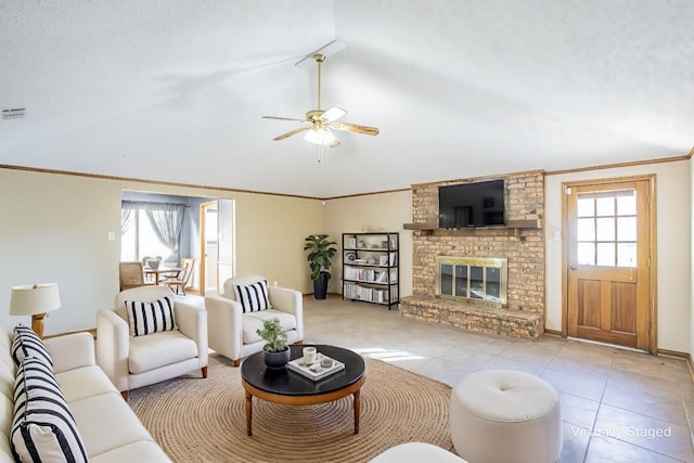 living room featuring crown molding, vaulted ceiling, a brick fireplace, ceiling fan, and light tile patterned flooring