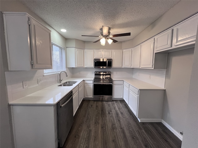 kitchen with appliances with stainless steel finishes, dark hardwood / wood-style flooring, sink, and white cabinets